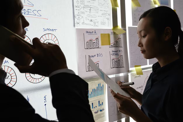 male-female-colleagues-standing-by-glass-wall-with-business-charts-diagrams_1098-20211.jpg